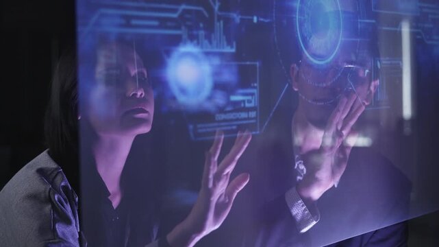 A professional man interacts with a high-tech circular data interface on a large digital screen, featuring graphs and data elements in a glowing blue theme.