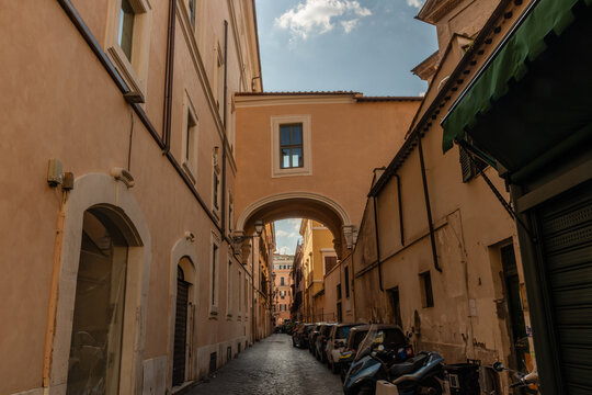 Scenic narrow old city alley with a skybridge connecting the two sides of the street in springtime, Rome, Italy