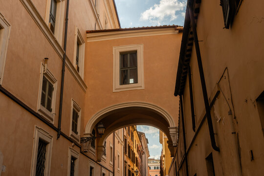 Scenic narrow old city alley with a skybridge connecting the two sides of the street in springtime, Rome, Italy
