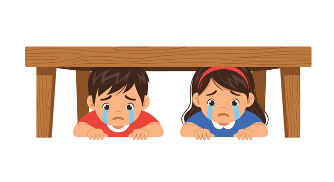 Two young children crying and hiding together under a wooden table in fear or sadness during a difficult situation.