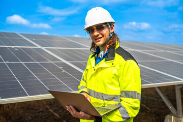 Happy construction worker standing by photovoltaic panels. Professional builder supporting eco...