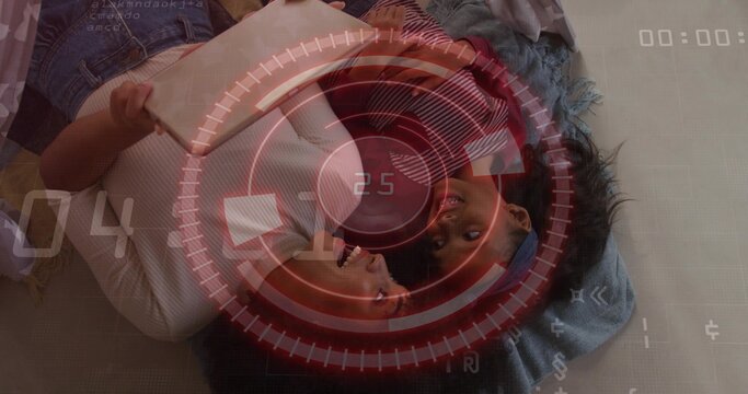 Lying adult woman white tank and child red headband sharing beige tablet on bed, HUD overlay