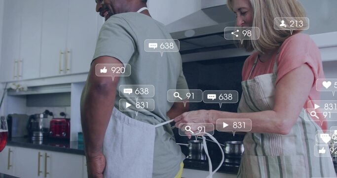 Tying woman fastening apron strings of man in modern kitchen, with pots, notification overlays