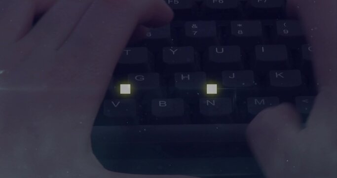 Pair of hands typing on keyboard at desk with yellow key lights and wrist rest visible