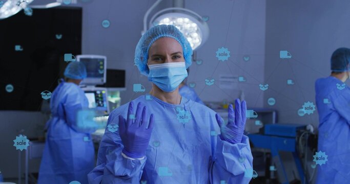 Holding raised purple gloves, lead surgeon preparing surgery by monitors, with digital overlay