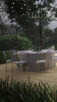 A round table is set with white tablecloth and chairs in a garden area. Trees surround the space with greenery. Lights hang above, indicating a gathering is planned.