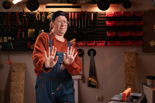 No thanks. Carpenter woman rejecting shake hands to decline offer looking at camera working in her carpentry workshop
