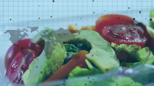 Vertical video: Panning camera revealing salad in clear tub on map, showing tomato, avocado gloss