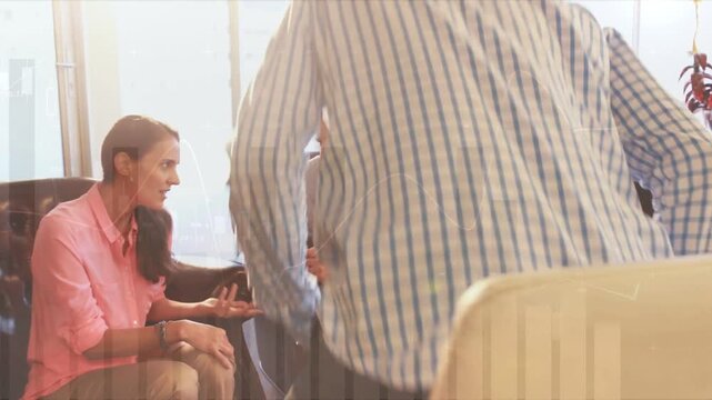 Talking colleagues in pink blouse, blue shirt gesturing in office lounge with tufted armchairs