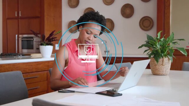 Vertical video: Seeing checkmark icon woman in coral top entering bills at kitchen table on laptop