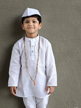 Cute Indian boy in traditional Marathi attire with Gandhi cap and tulsi mala, representing Warkari culture during Palkhi festival, smiling in simple devotional style.