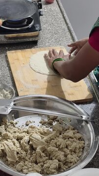 Indian woman preparing jowar roti from dough to cooking on tawa, showcasing traditional handmade flatbread process in home kitchen with authentic rural style cooking.