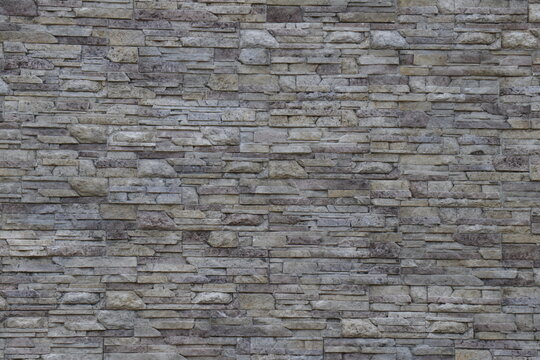 textured stone wall surface with varied gray bricks in horizontal layout