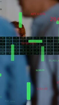 Vertical video: Reacting to HUD, man at desk in rolled sleeves reviewing laptop or tablet with team