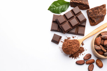 Naklejka premium Cocoa powder, beans, chunks, pieces of chocolate and green leaf on white background, flat lay. Space for text