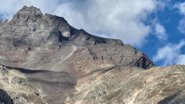 Aerial panning shot of a rugged, barren mountain ridge in the high-altitude Himalayas.