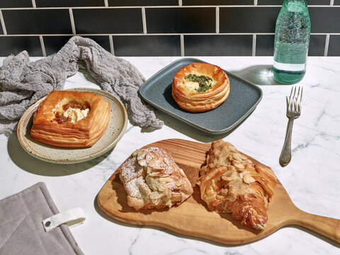 Sweet and savory French pastries sitting on white marble table