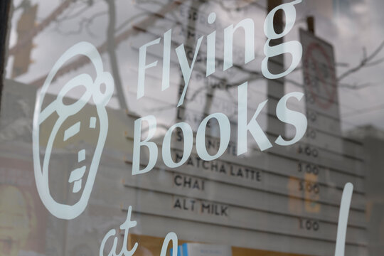 exterior building window and sign of Flying Books at Neverland, a book store, located at 371 Queen St W, Toronto