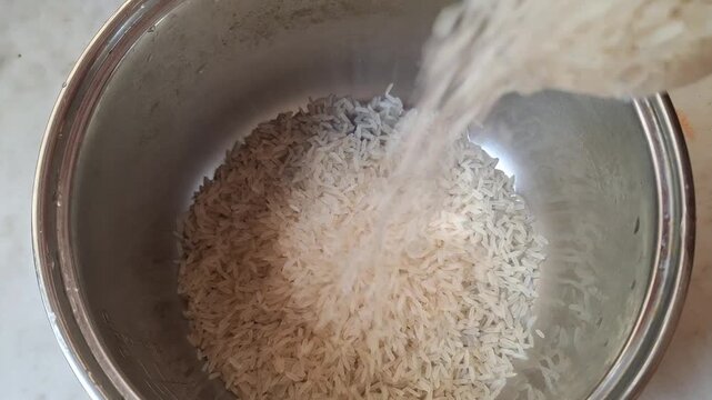 Wider Perspective of Raw White Rice Being Poured into a Cooking Pot