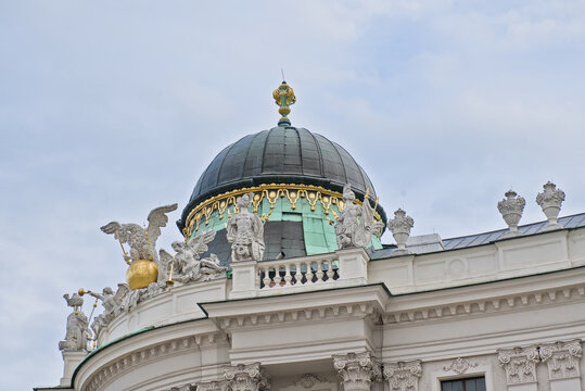 Architecture detail of Michaelertract palace, with sculptures of a grifon, angels and soldiers. Hofburg, Vienna, Austria 