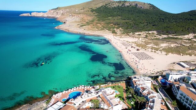 4K Aerial Drone Flight over Cala Mesquida Beach. Cinematic View of Coastal Hotels, Luxury Villas and Turquoise Sea Water. Flight along Scenic Sandy Bay and Dunes. Mallorca Spain. High Quality