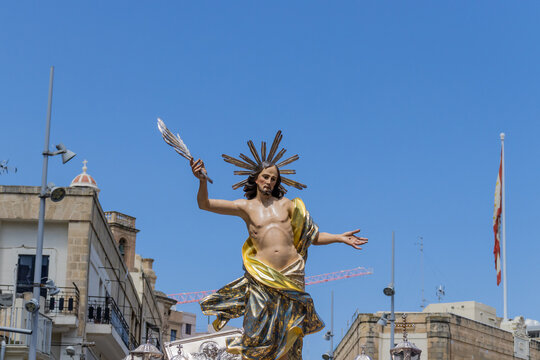 Gilded Statue Of the Resurrected Jesus In Outdoor Religious Procession Under Blue Sky