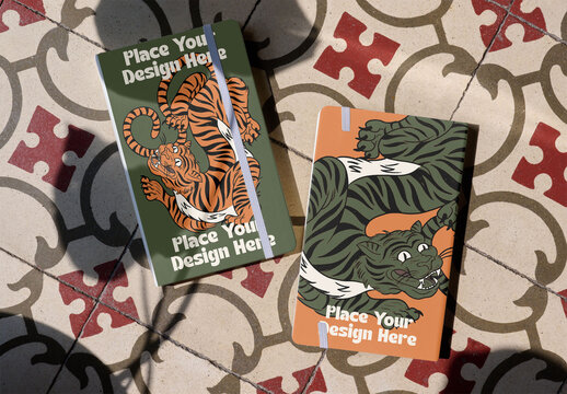 Two Book Covers Lie on a Patterned Floor