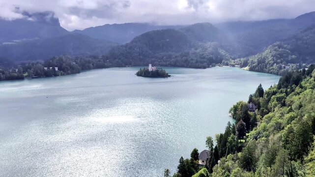 lake bled island church reflection with castle on mountain cliff background (famous european travel tourism destination in julian alps) slovenia europe scenic landscape sunset glow boat rowing nature