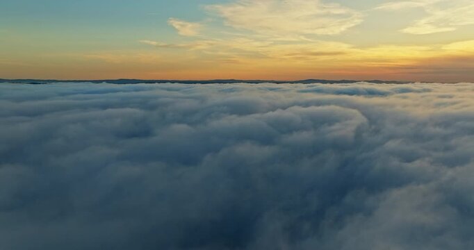 Flying above clouds sunset bright sun rays shining through mist. Dreamy heavenly atmosphere golden hour sunlight. Cinematic aerial perspective nature beauty professional stock footage.
