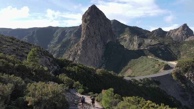 Tourists are walking along the nature trail to Roque de Agando in La Gomera. Canary Islands.
