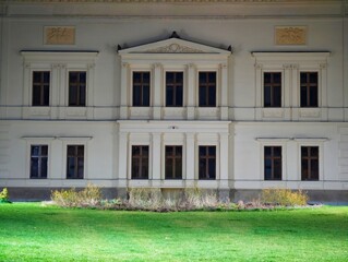 Classical mansion with symmetrical features. Historic neoclassical house with manicured surroundings © Vladimir