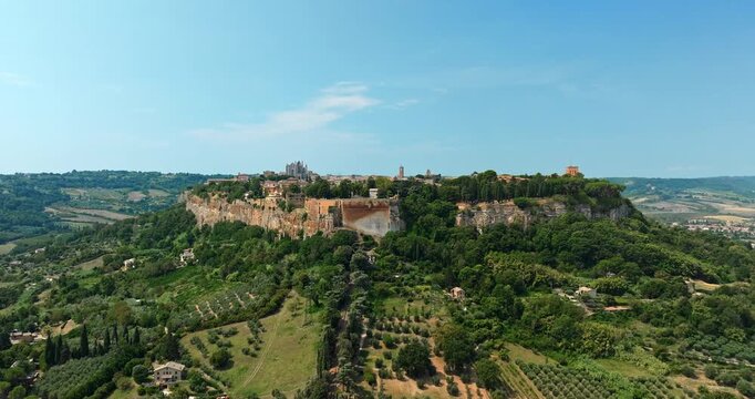 Panoramic top view Orvieto Umbria Italy. Iconic medieval settlement tuff rock plateau mountain landscape beautiful scenery summer vacation destination aerial cinematography quality video.