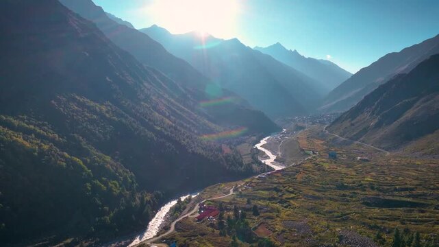 Cinematic Drone shot of the winding Baspa River bathed in golden hour sunlight in Chitkul, Kinnaur, Himachal Pradesh.