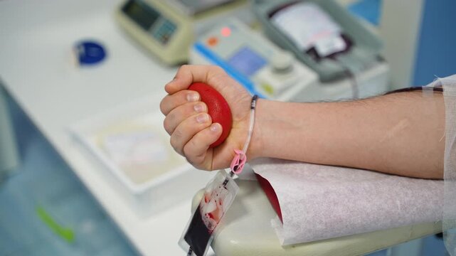 Male blood donor squeezing a red stress ball
