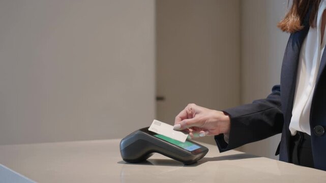 Woman using a credit card to pay for a purchase at a store.