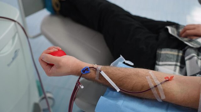 Male patient squeezing stress ball during blood donation