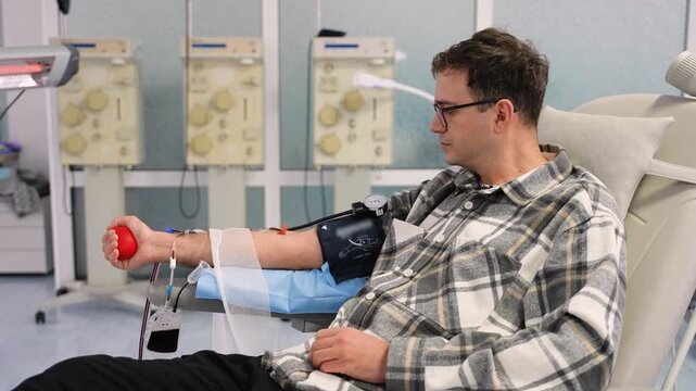 Young man donating blood in a modern hospital center