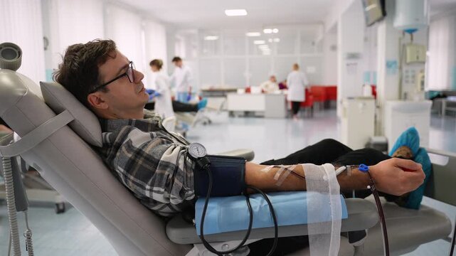 Male volunteer squeezing stress ball while donating blood