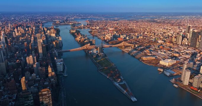 Sunset in gorgeous New York, USA. Drone flight over the river approaching the Queensboro Bridge.