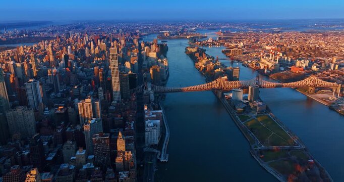 Approaching the Queensboro Bridge lit by the setting sun. Vast panorama of gorgeous New York, USA at sundown.