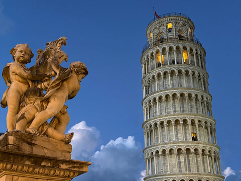 Leaning Tower of Pisa and Fontana dei Putti Statue of angels on Square of Miracles, Italy.