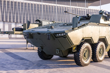 Military equipment and army equipment.. Parked armored personnel carrier under sunlight, sixwheel chassis and low profile turret visible, urban exhibition site conveying readiness, tactical © NastyaPhoto