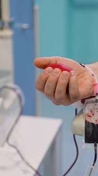 Male hand squeezing stress ball during blood donation