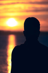 silhouette of a man near a lake during sunset © Mathæus Andersen