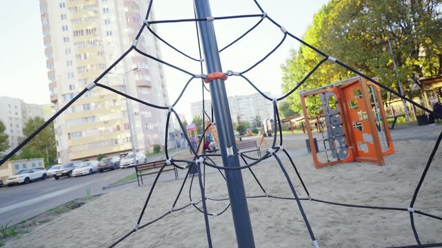 Safe rope maze for children climbing on playground in urban park. Attraction for active games and kids physical development in yard