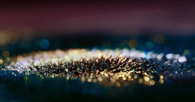 Footage of metal particles reacting to magnetic forces, forming vibrant abstract shapes on a black backdrop. Ideal for enhancing motion graphics and visual effects in artistic projects