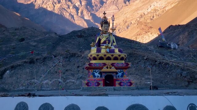 Cinematic drone reveal shot of Padmasambhava Guru Rinpoche statue in the high-altitude desert of Spiti Valley.