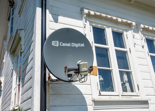 Gothenburg, Sweden - August 03 2021: Satellite dish mounted on white wooden house exterior.