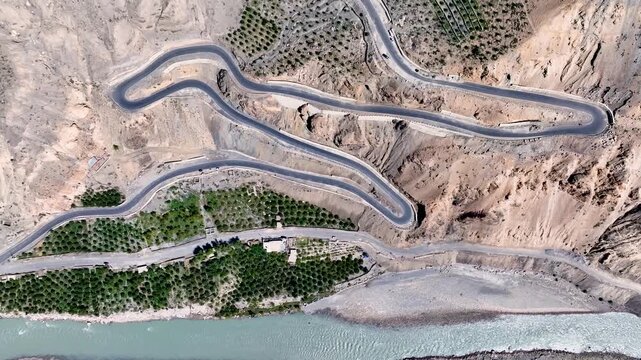 Top-down aerial aerial drone shot of the zigzagging Ka Loops mountain pass and highway in Himachal Pradesh, India.