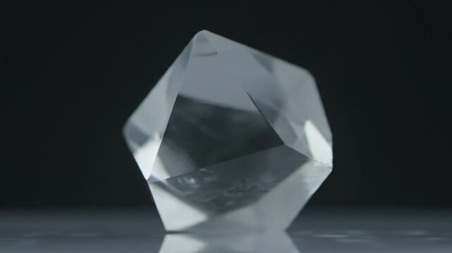 Close-up of a raw, uncut diamond rotating slowly against a dark background